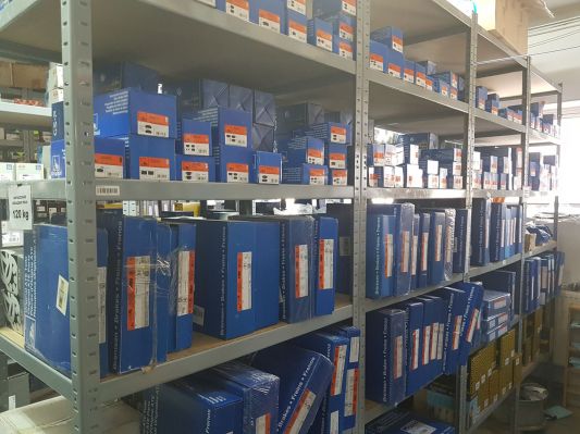 części samochodowe w opakowaniach na regale w sklepie AUTKO