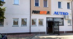 Wejście do sklepu motoryzacyjnego AUTKO widziane z zewnątrz
