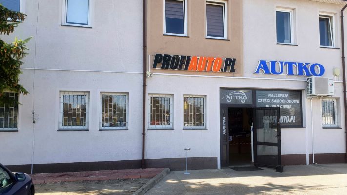 Wejście do sklepu motoryzacyjnego AUTKO widziane z zewnątrz